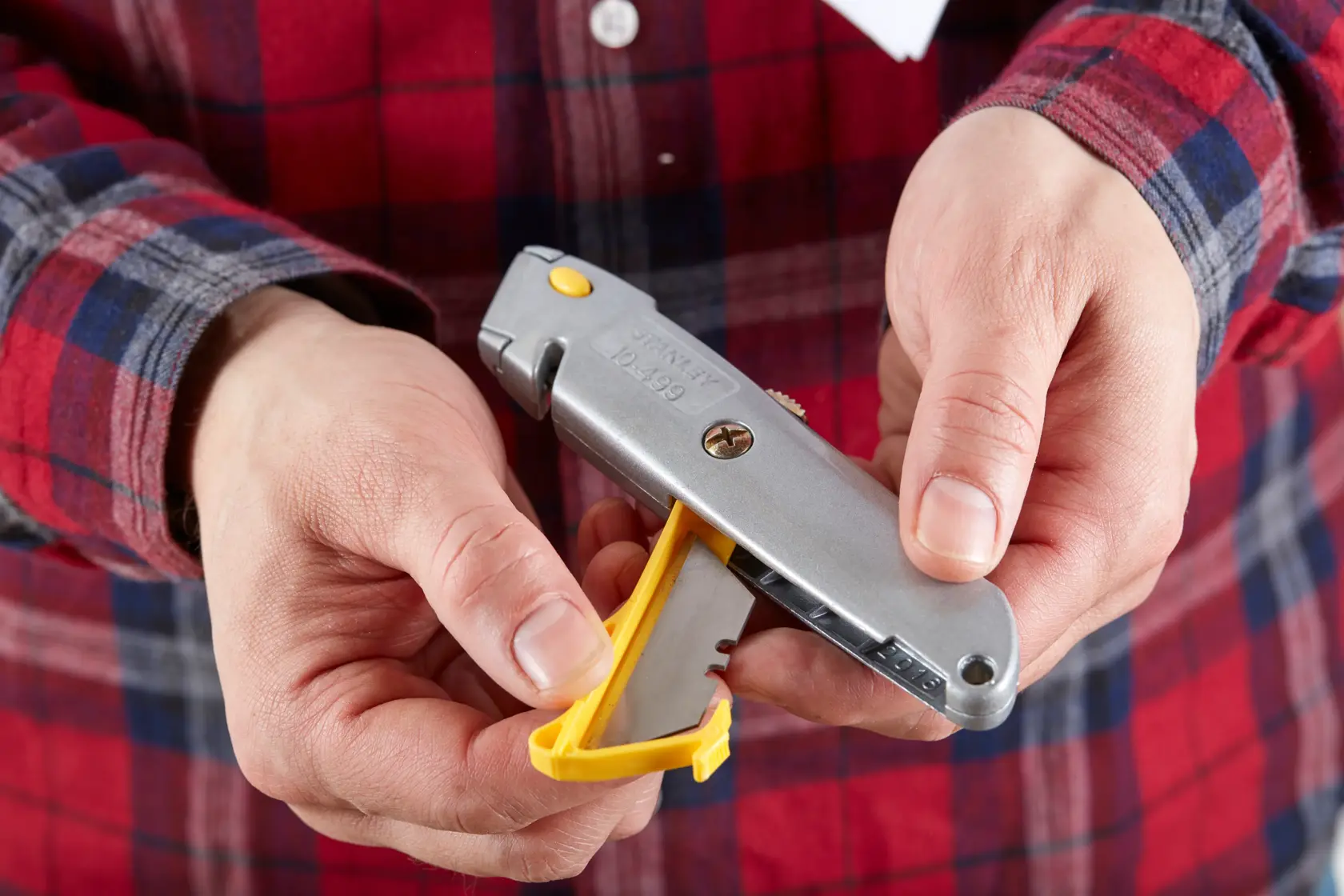 Photo of STANLEY 0-10-499 utility knife with yellow blade compartment held in hand, Product Category: Photography.