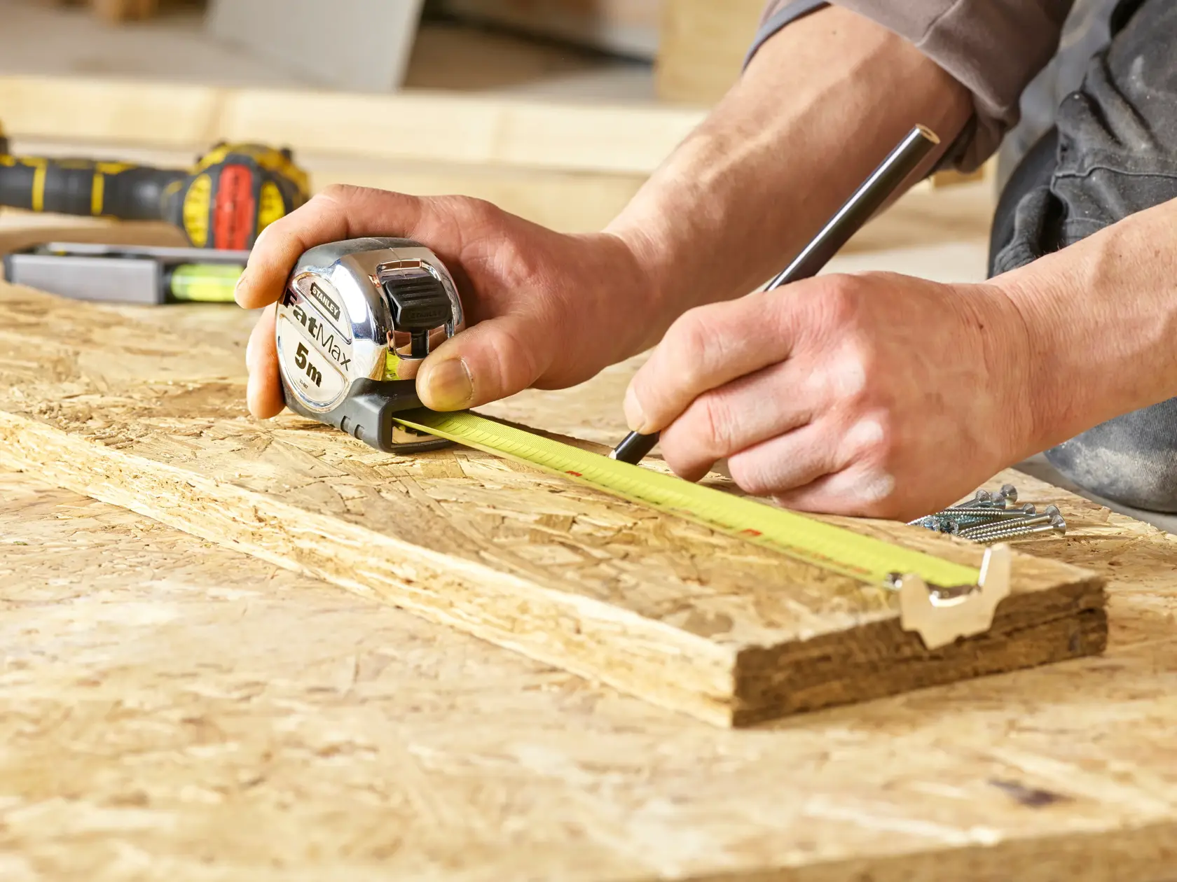 STANLEY 0-33-887 tape measure used for marking wood in a workshop, close-up photography.