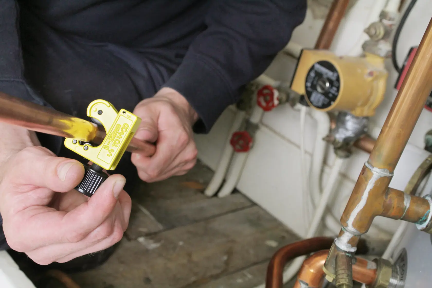STANLEY 0-70-447 pipe cutter in use cutting copper pipe in plumbing setting.