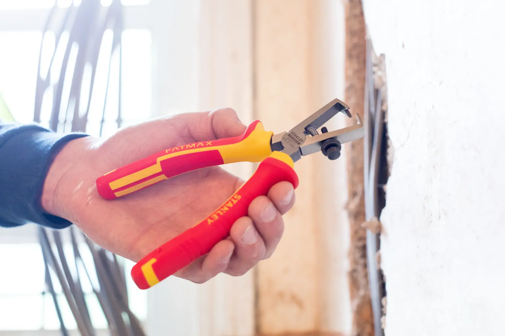 Photo of STANLEY 0-84-010 insulated wire stripper with red and yellow handles in use.