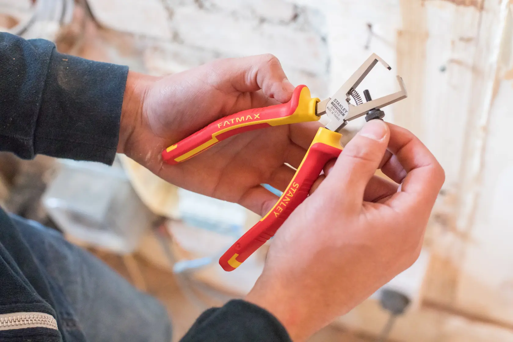 STANLEY 0-84-010 insulated pliers with red and yellow handles in use, close-up photography.