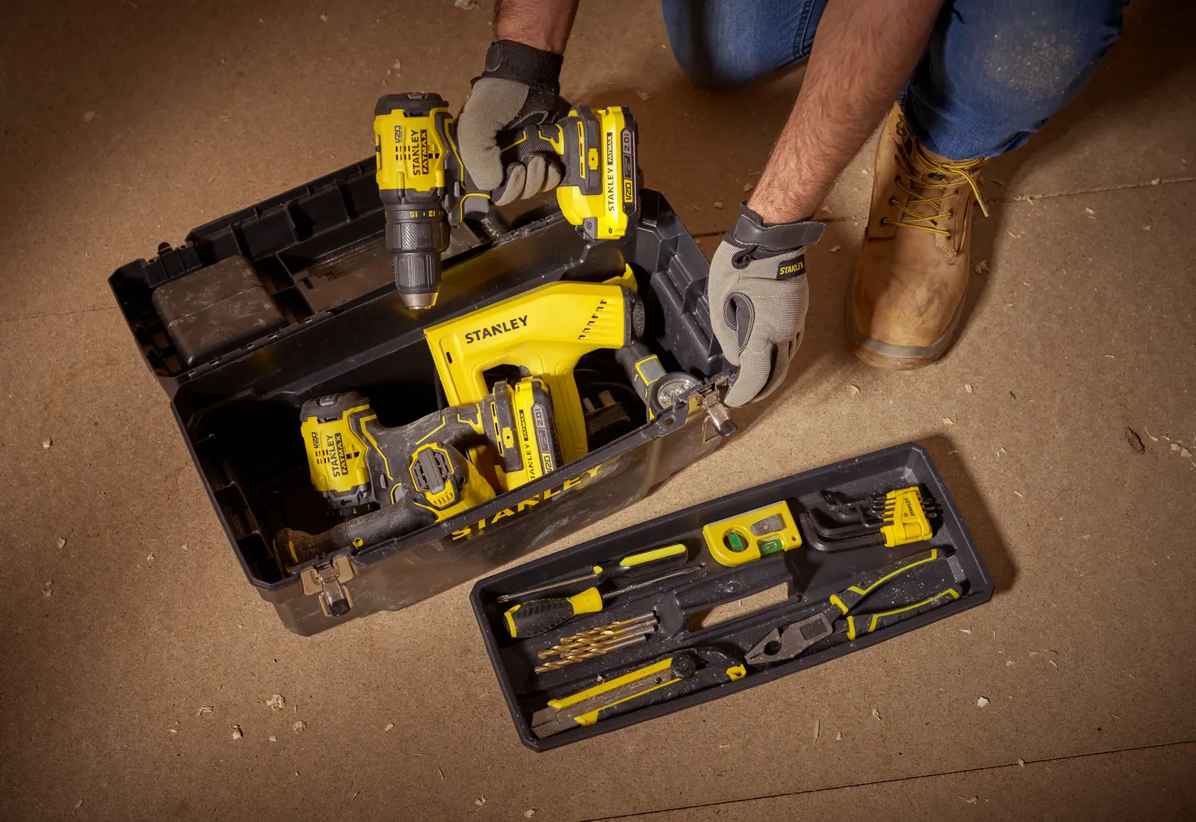 STANLEY 1-94-858 tool box with yellow power tools and hand tools, photo from above on workshop floor.