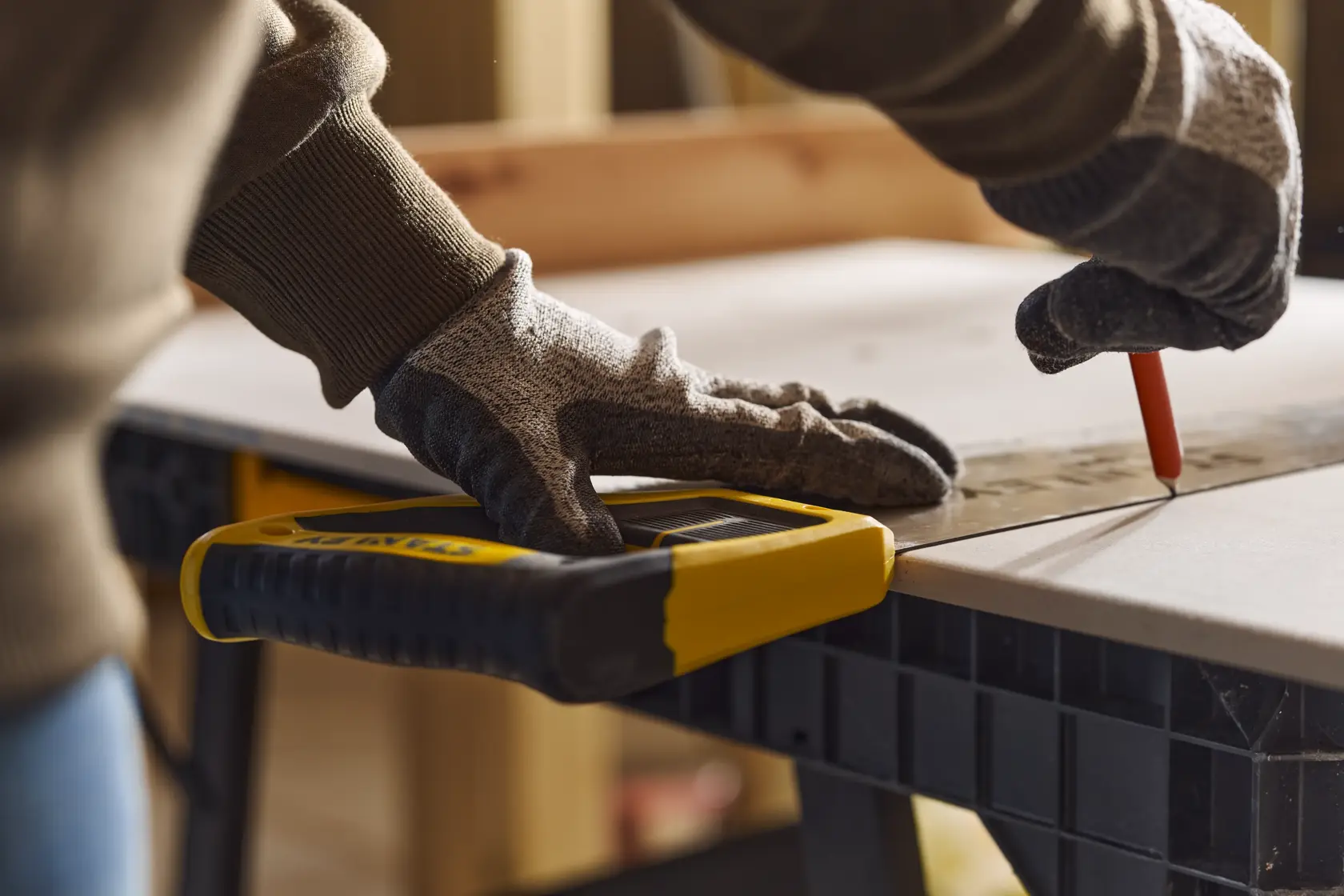 Photo of STANLEY 2-15-244 hand saw on workbench, person wearing gloves marking wood.