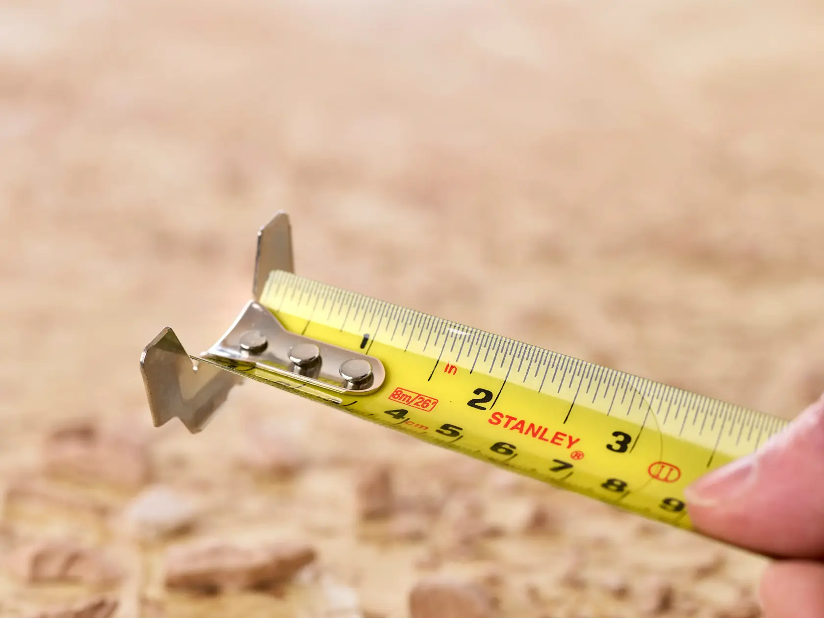STANLEY 5-33-891 tape measure close-up showing yellow blade with clear markings in outdoor setting.