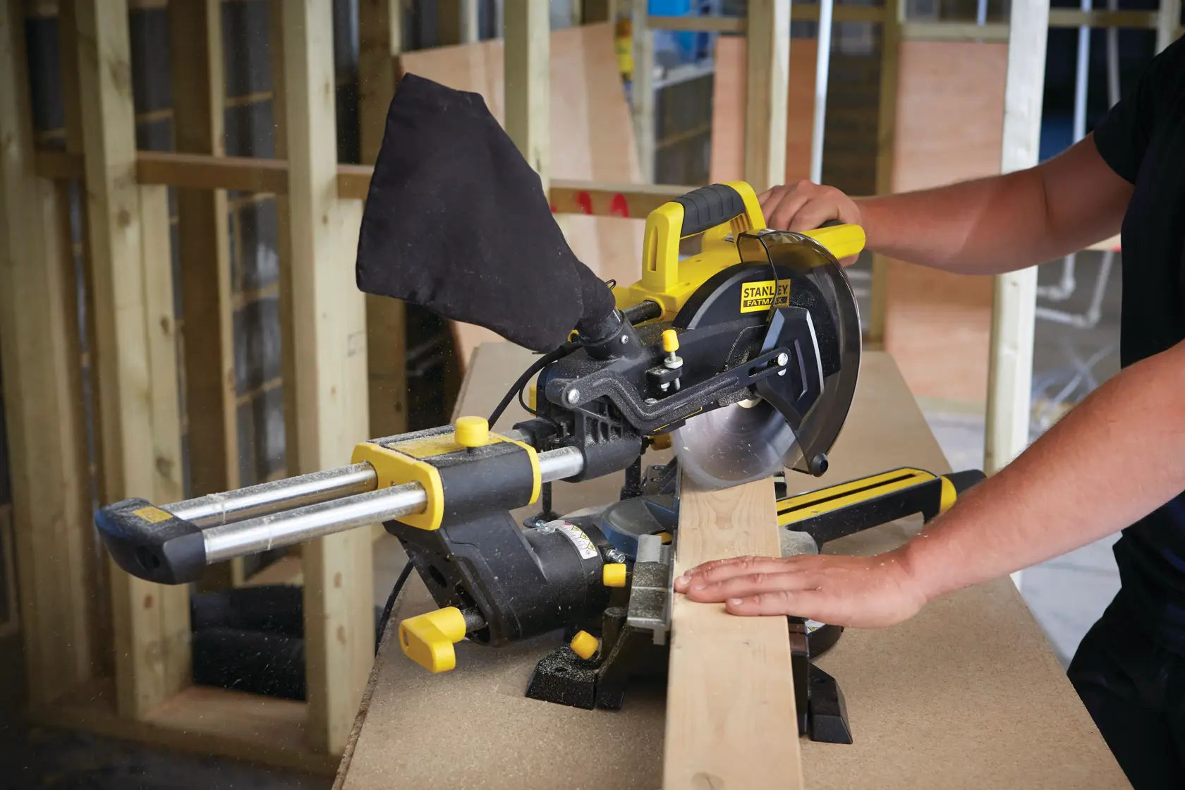 STANLEY FME721-GB sliding mitre saw cutting wood, photographed in use on a workbench.
