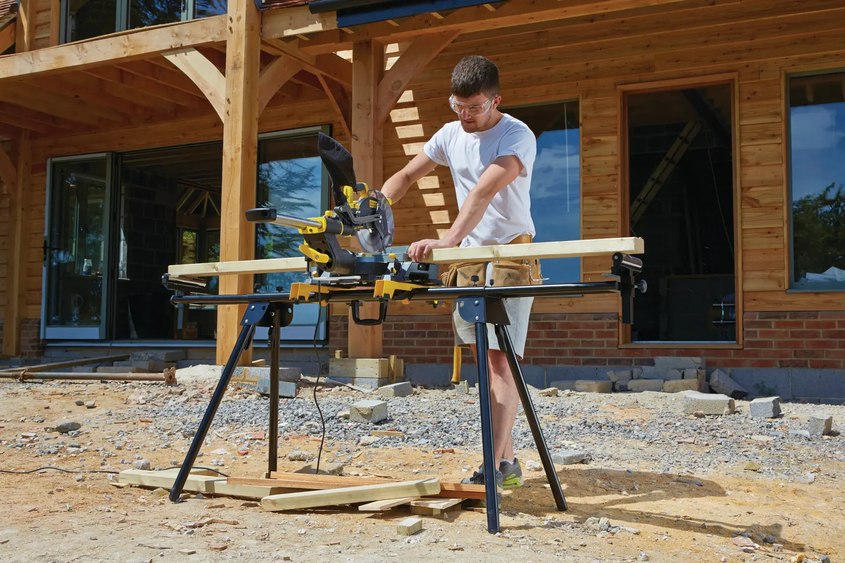 STANLEY FME721-GB mitre saw in use outdoors, cutting wood at a construction site.