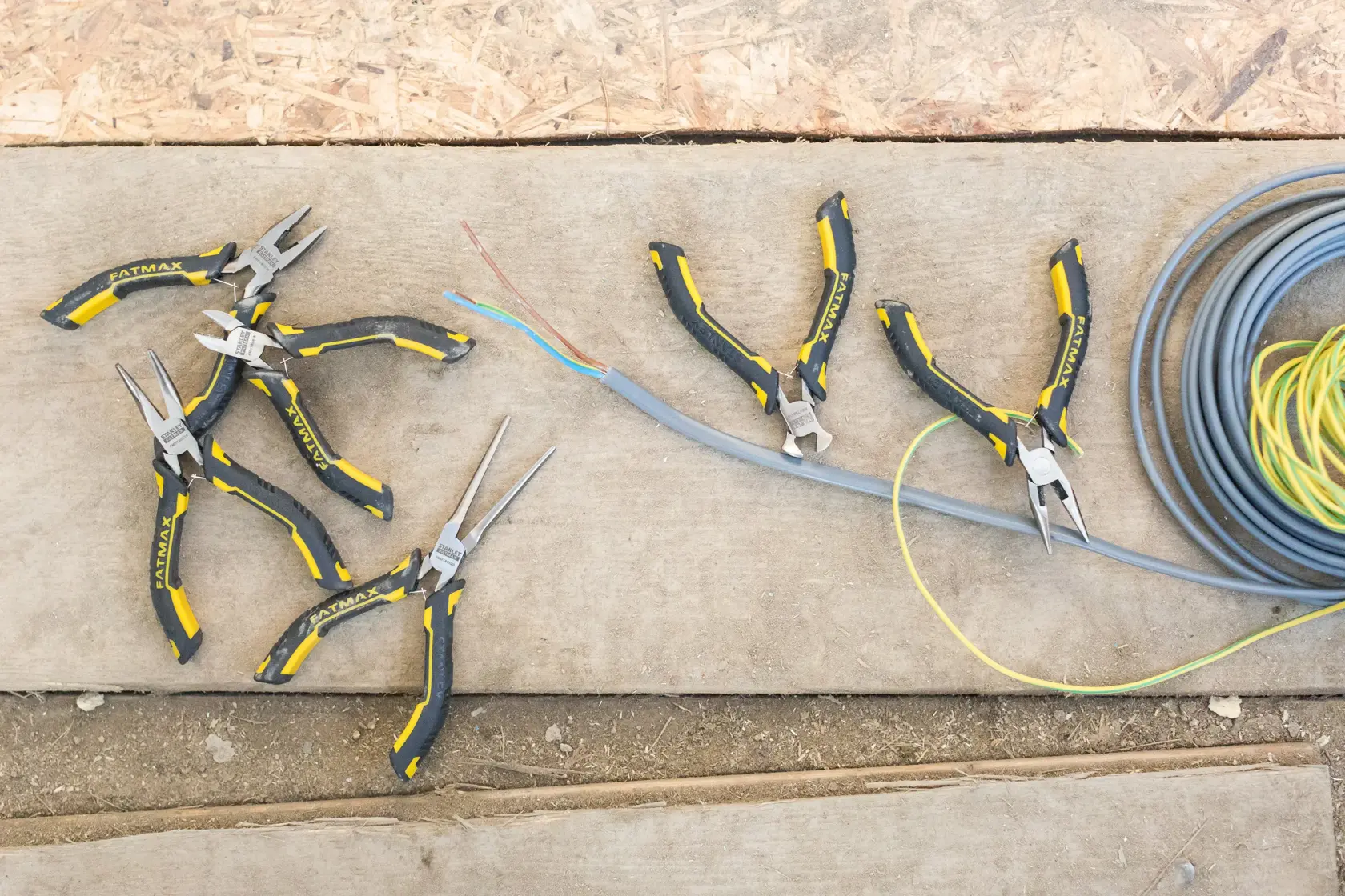 STANLEY FMHT0-80541 pliers set with black and yellow handles on a worksite, shown from above.