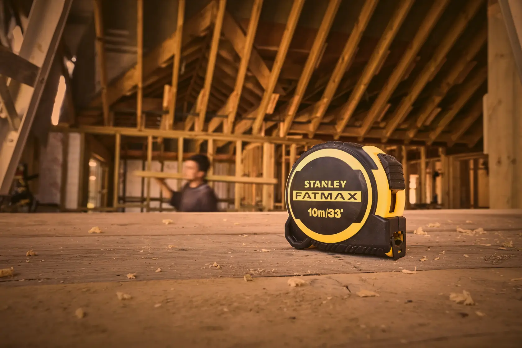 STANLEY FMHT33104-5 tape measure on wooden floor in construction site, yellow and black, 10m/33ft.