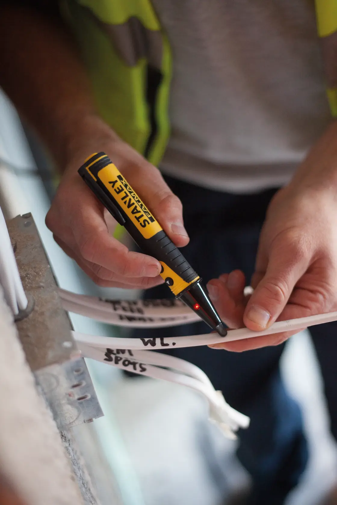 Photo of STANLEY FMHT82567-0 voltage tester used on labeled electrical cables.