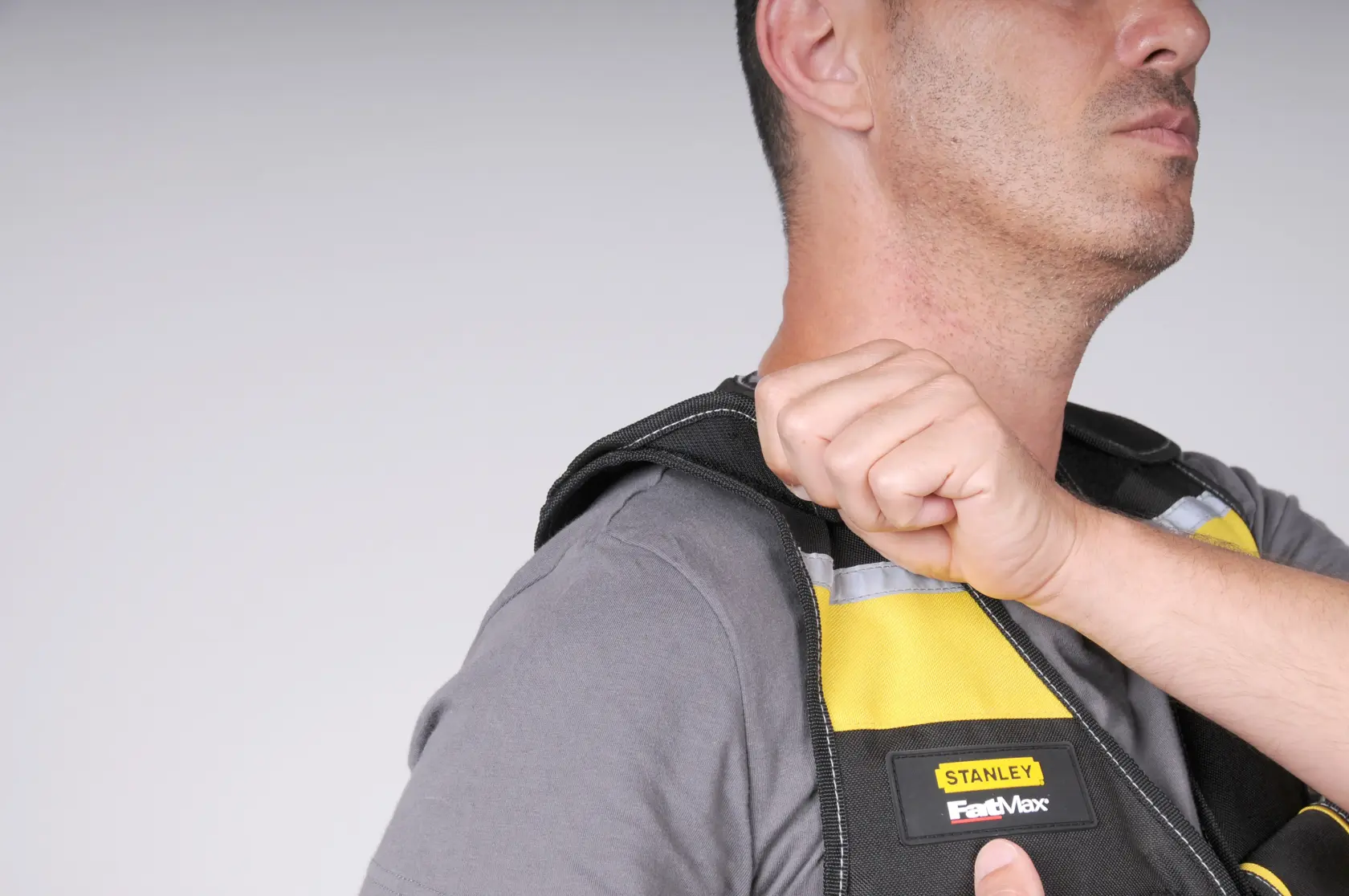 STANLEY FMST1-71181 vest close-up, yellow and black, FastMax logo, shoulder adjustment shown.