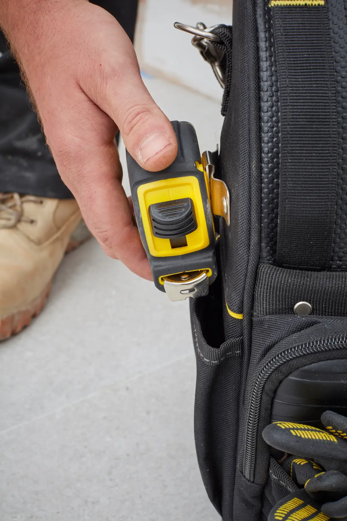 STANLEY FMST83296-1 tool bag close-up with yellow tape measure clipped to pocket.