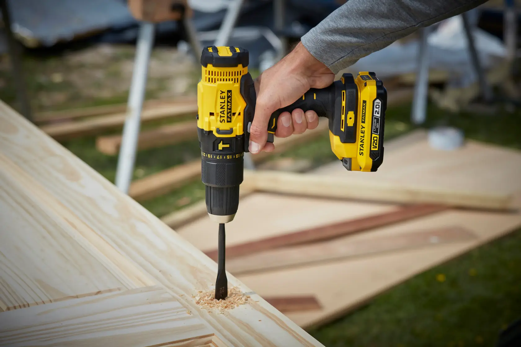 STANLEY SFMCD711D11 cordless drill in use on wood, product photography outdoors.