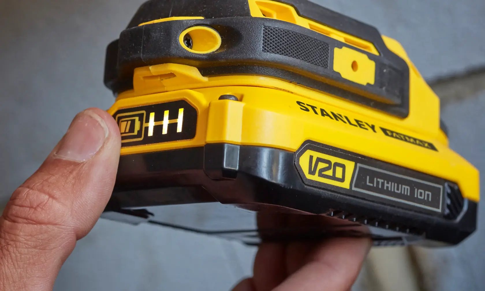 Stanley V20 SFMCD711D21 lithium ion battery with charge indicator, close-up photo.