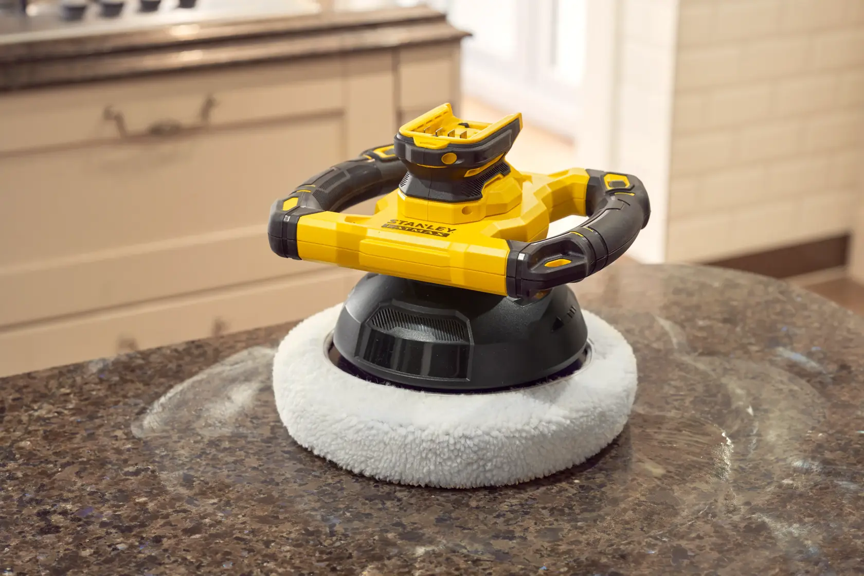 STANLEY SFMCE100D2 cordless polisher with black and yellow body on a kitchen countertop.
