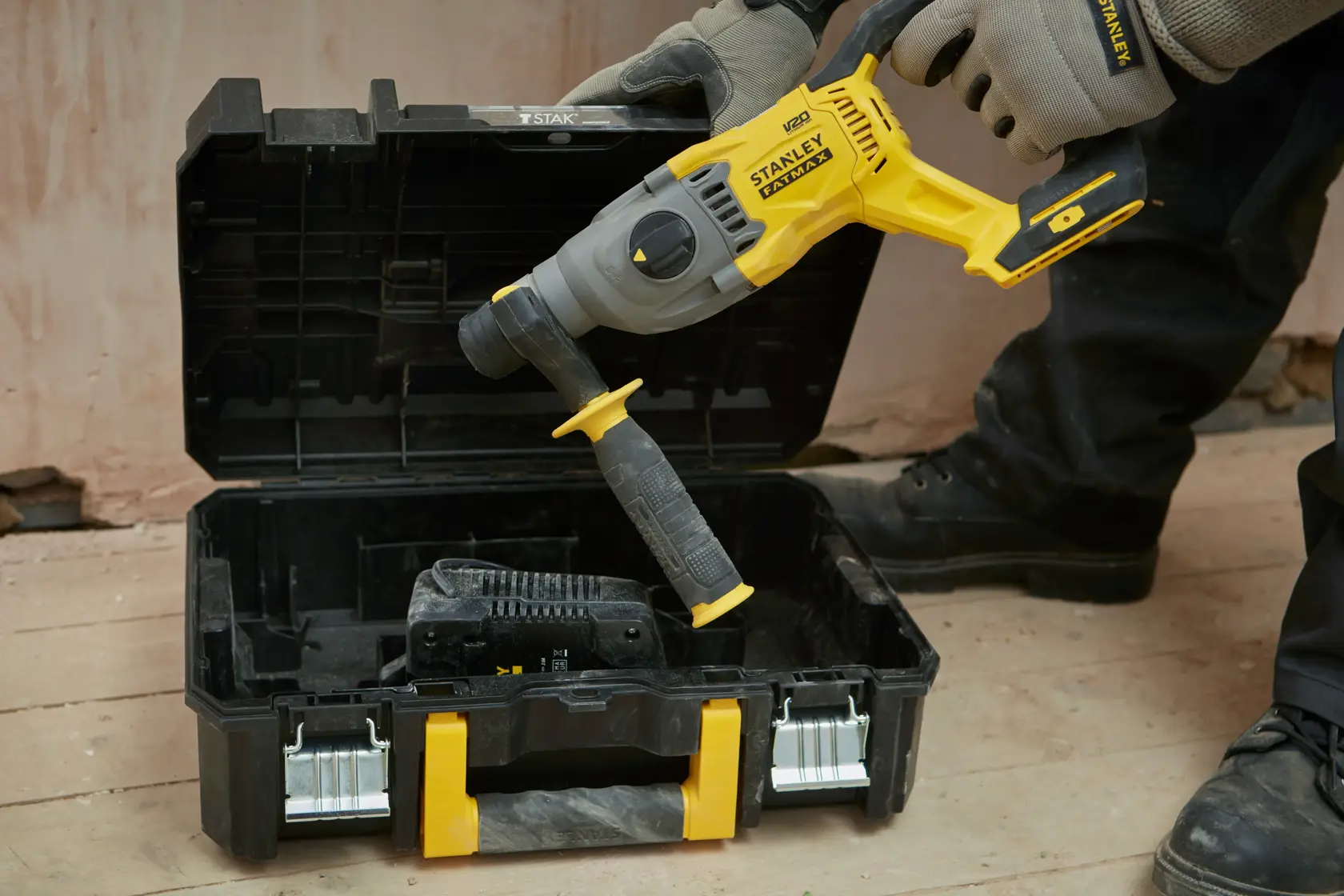 STANLEY SFMCH900M12 rotary hammer drill with side handle placed in open black and yellow carrying case, front angle.