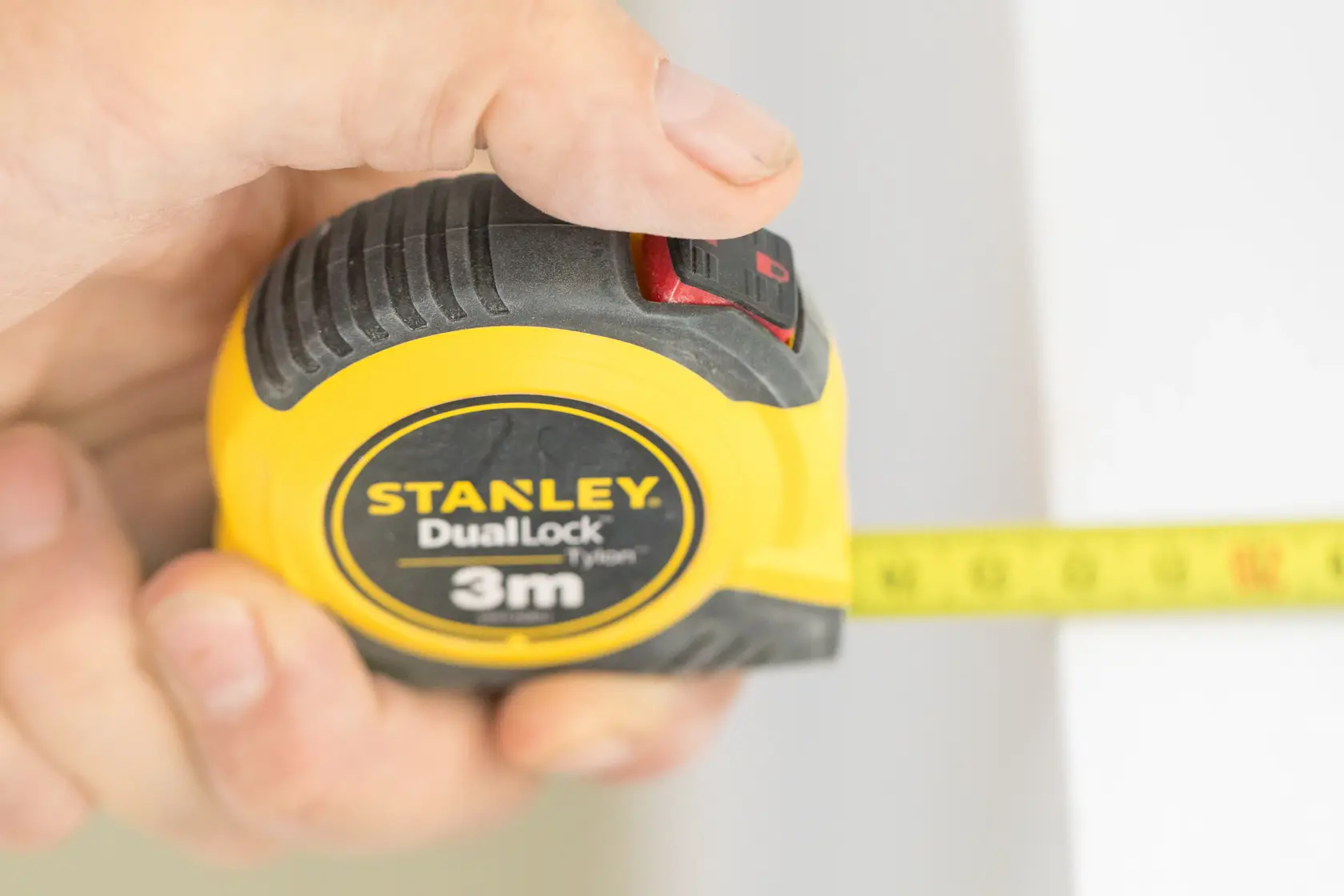 STANLEY STHT36806-0 tape measure with yellow and black casing, 3m length, shown in hand during measurement.