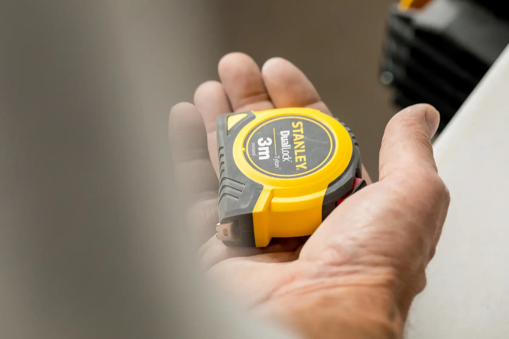 STANLEY STHT36806-0 yellow and black tape measure, 3m, held in a hand, close-up photo.