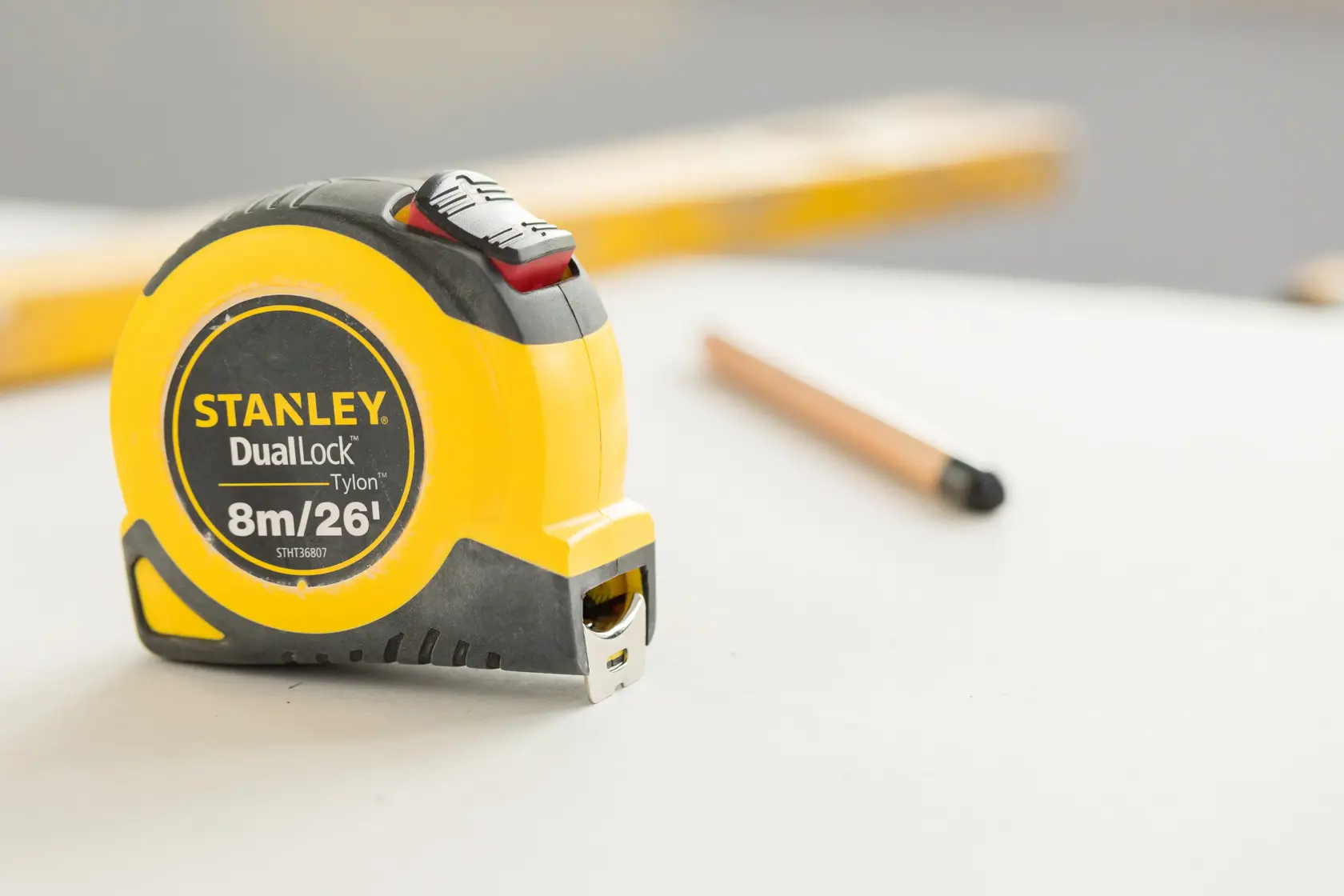 STANLEY STHT36807-0 tape measure DualLock Tylon 8m/26ft on tabletop with pencil in background.