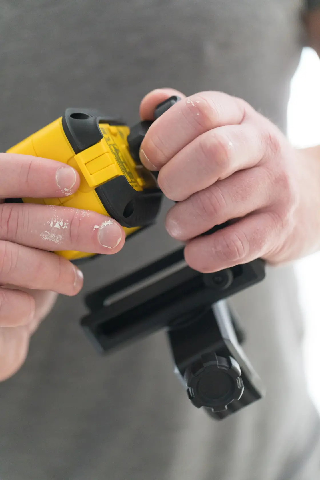 STANLEY STHT77503-1 laser level held and adjusted by hand, close-up photography, yellow and black design.