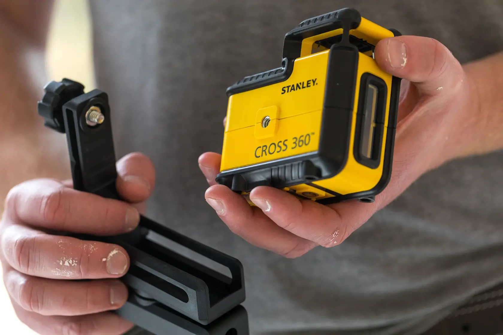 Photo of STANLEY STHT77504-1 CROSS 360 laser level with mounting bracket, held in hands.