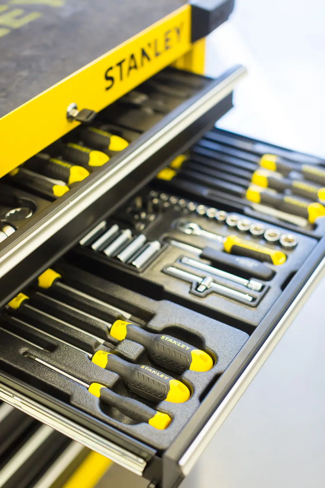 STANLEY STMT1-74306 tool drawer photography, yellow cabinet with assorted hand tools in foam organizer.
