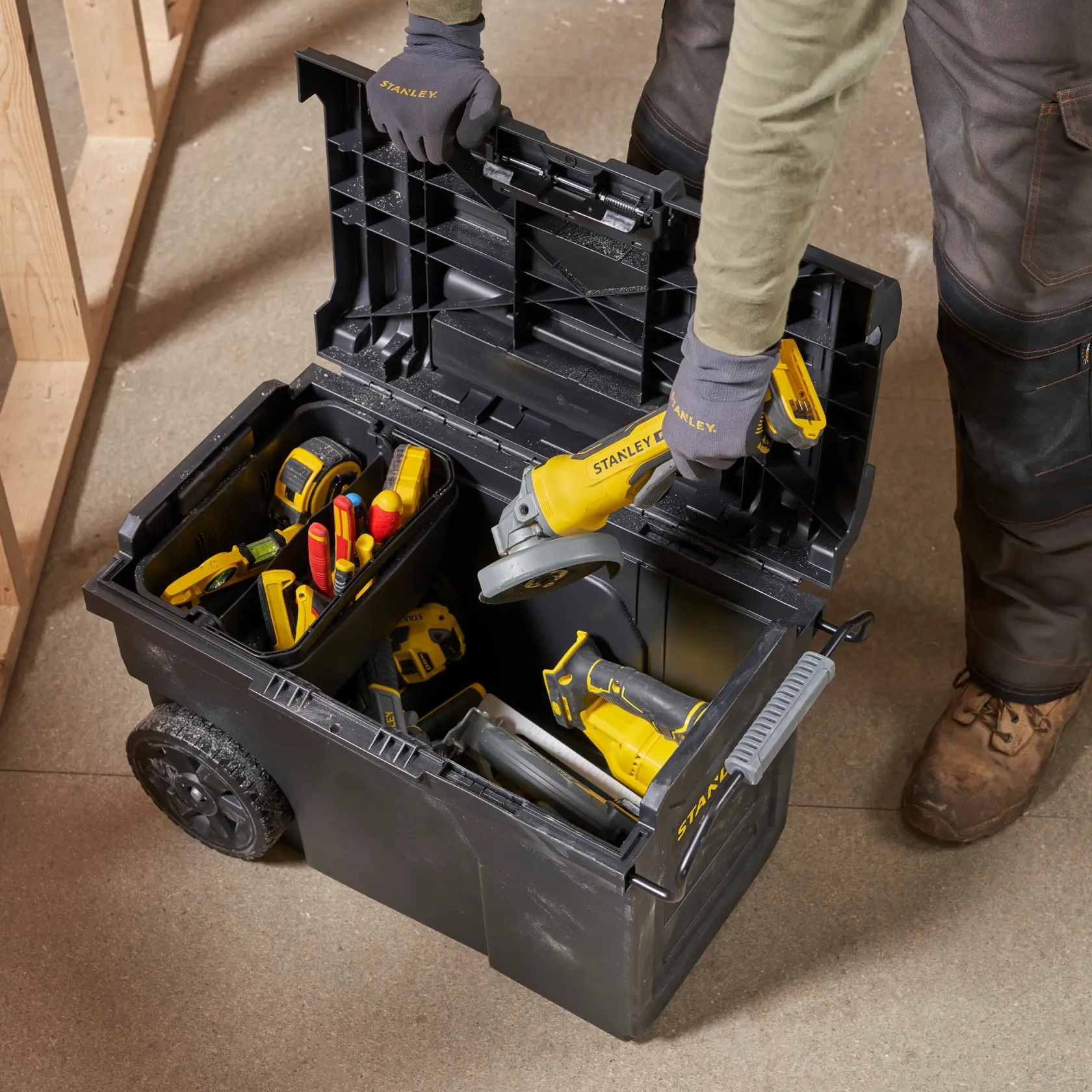 STANLEY STST1-70715 mobile tool chest top view with assorted yellow and red tools inside.