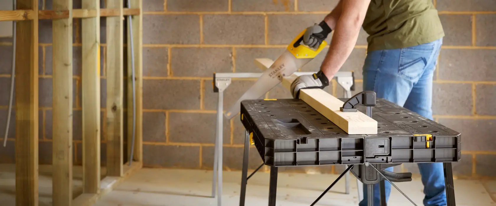 STANLEY STST83492-1 workbench used for woodworking, black plastic table, woodworking clamp, indoor workshop.