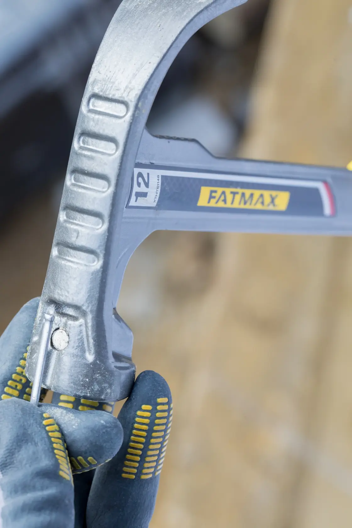 STANLEY XTHT1-51148 hammer close-up, held in gloved hand, showing silver head and FATMAX branding.